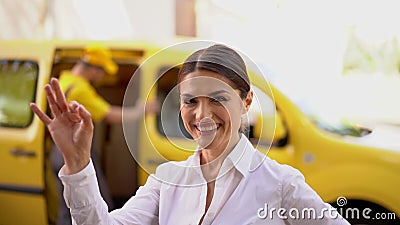  微笑的女实业家展示ok 被弄脏的送货车和传讯者在背景 股票视频