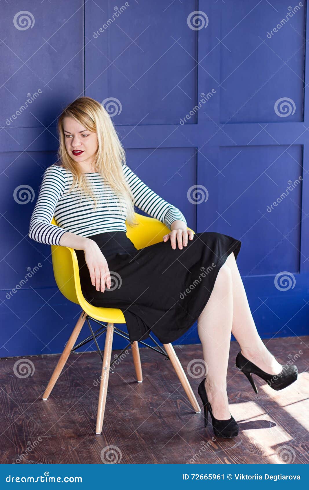 Vollbusige Blondine masturbiert auf einem Stuhl