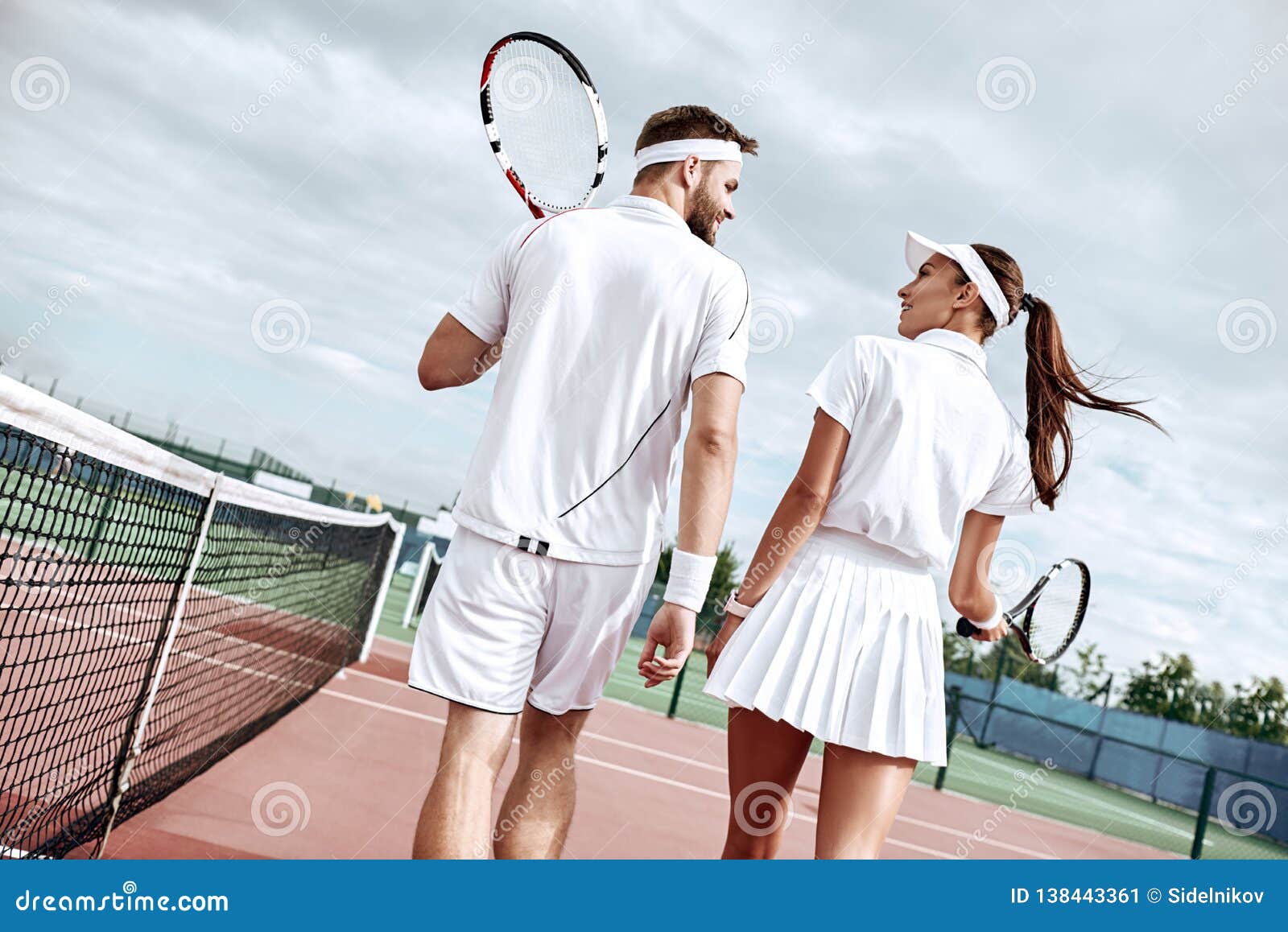 Пара играет. Счастливая пара на велосипедах. Парень на теннисном корте. Женатая пара. Интерес мужчины к женщине.