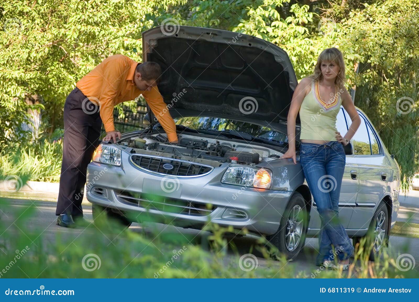 Мужчины машина и жена. Девушка и мужчина чинят машину. Мужчина чинит автомобиль женщине. Мужчина ремонтирует машину. Женщина помогает отремонтировать автомобиль.