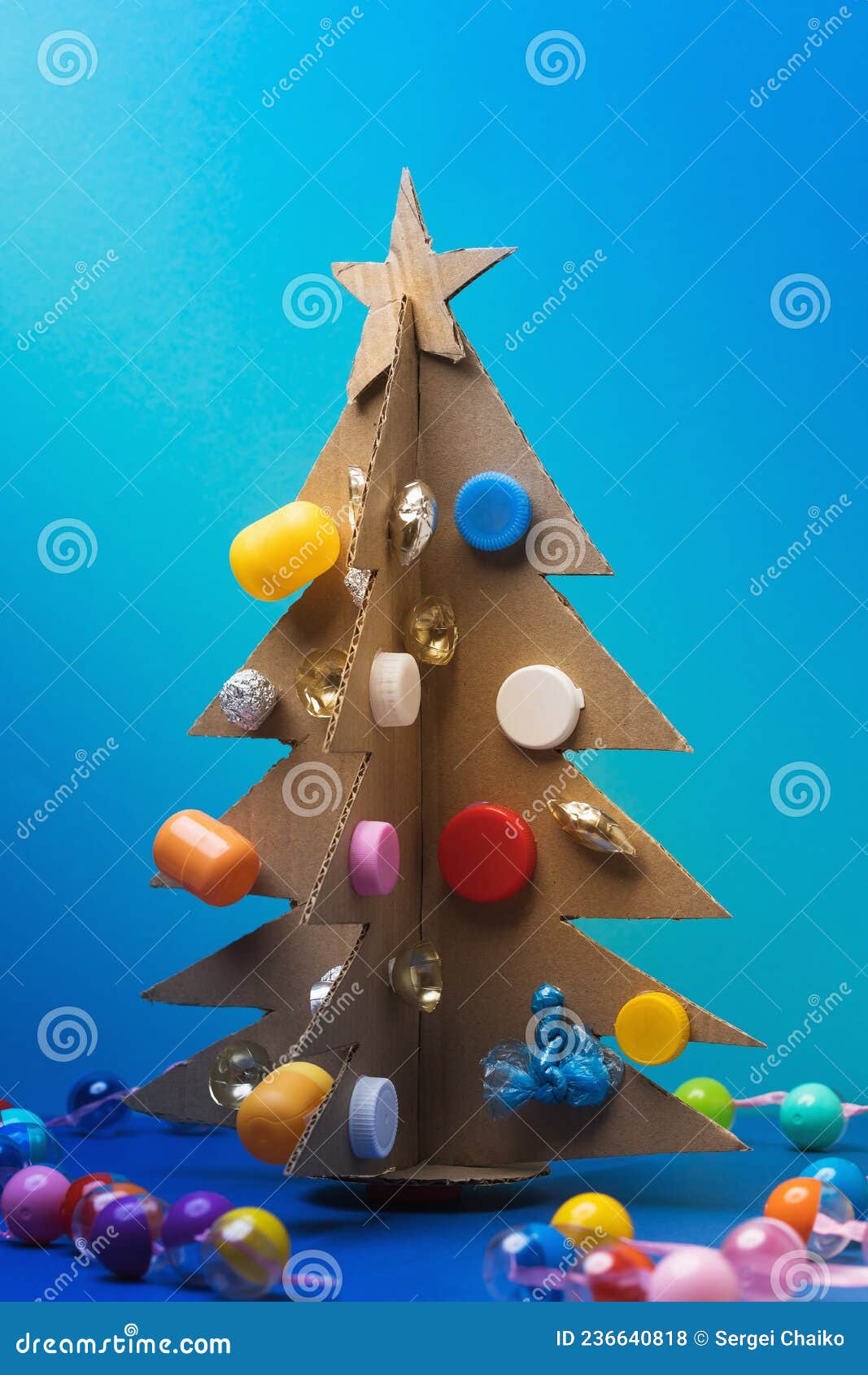 árvore De Natal Feita De Papelão Ondulado Decorado Com Vários Materiais  Reciclados Em Fundo Azul Foto de Stock - Imagem de figura, simplicidade:  236640818