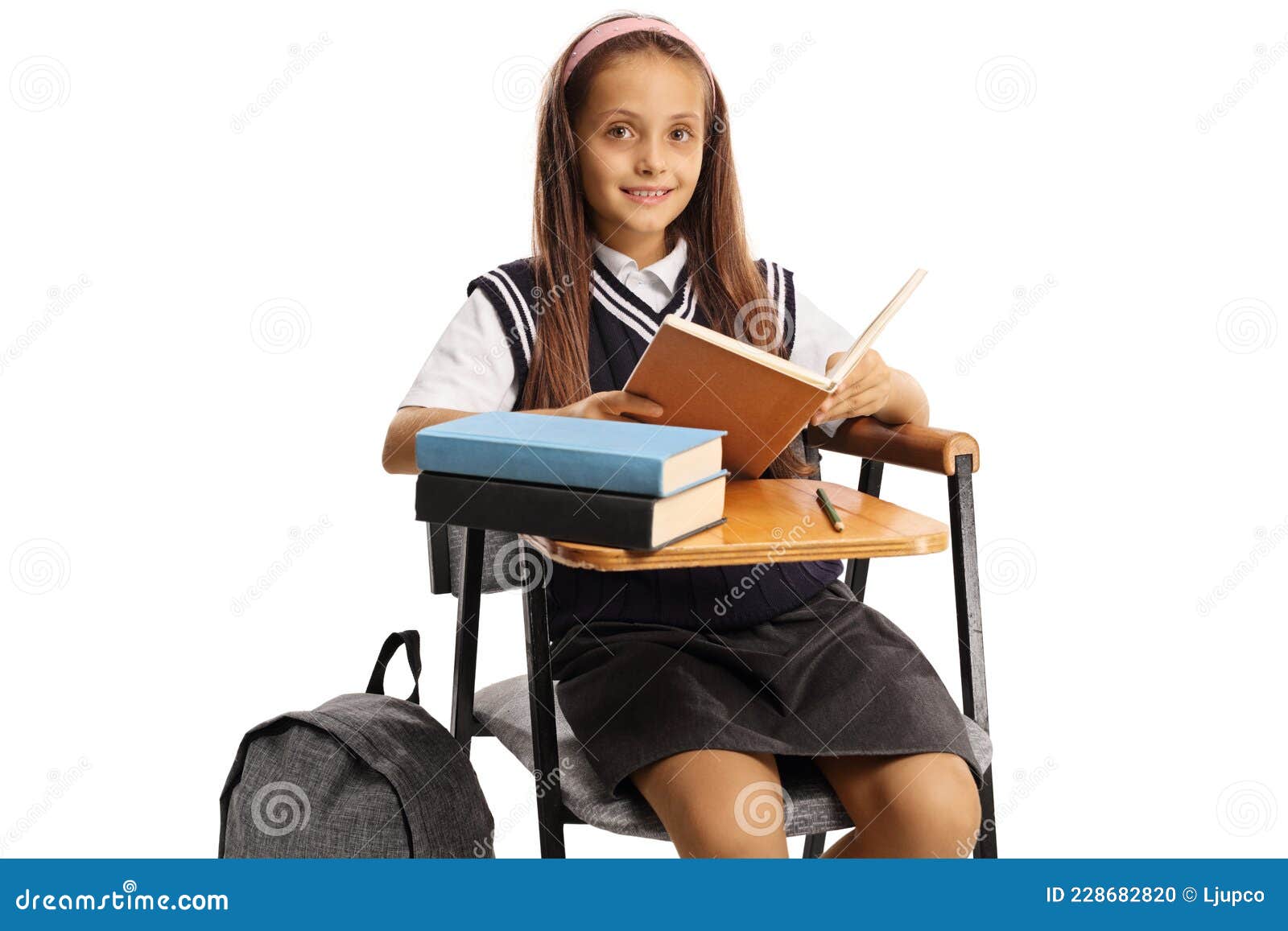 élève Assise Dans Une Chaise D'école Avec Un Livre Photo stock