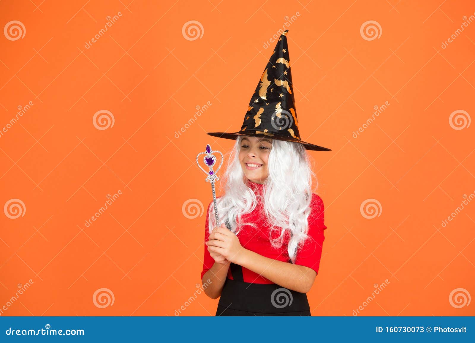 une enfant dans une sorcière costume ouverture une la magie livre