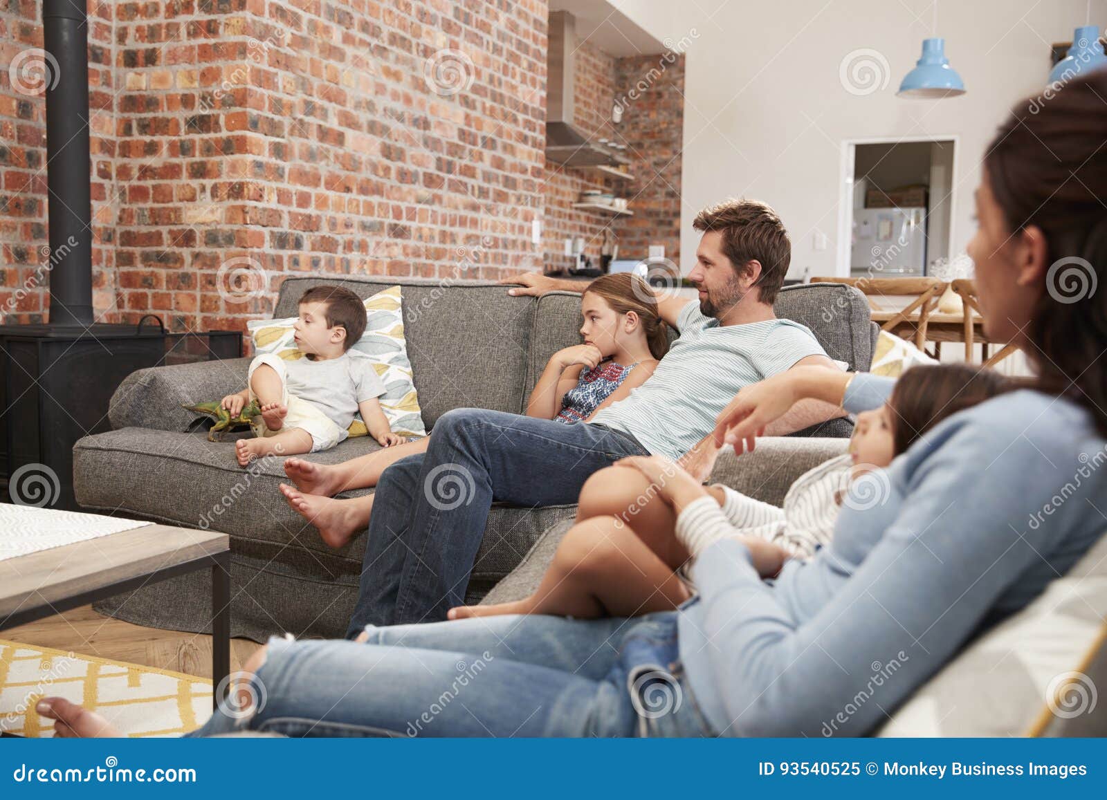 settlement The actual fence Η οικογένεια κάθεται στον καναπέ στην ανοικτή τηλεόραση προσοχής σαλονιών  σχεδίων Στοκ Εικόνα - εικόνα από : 93540525