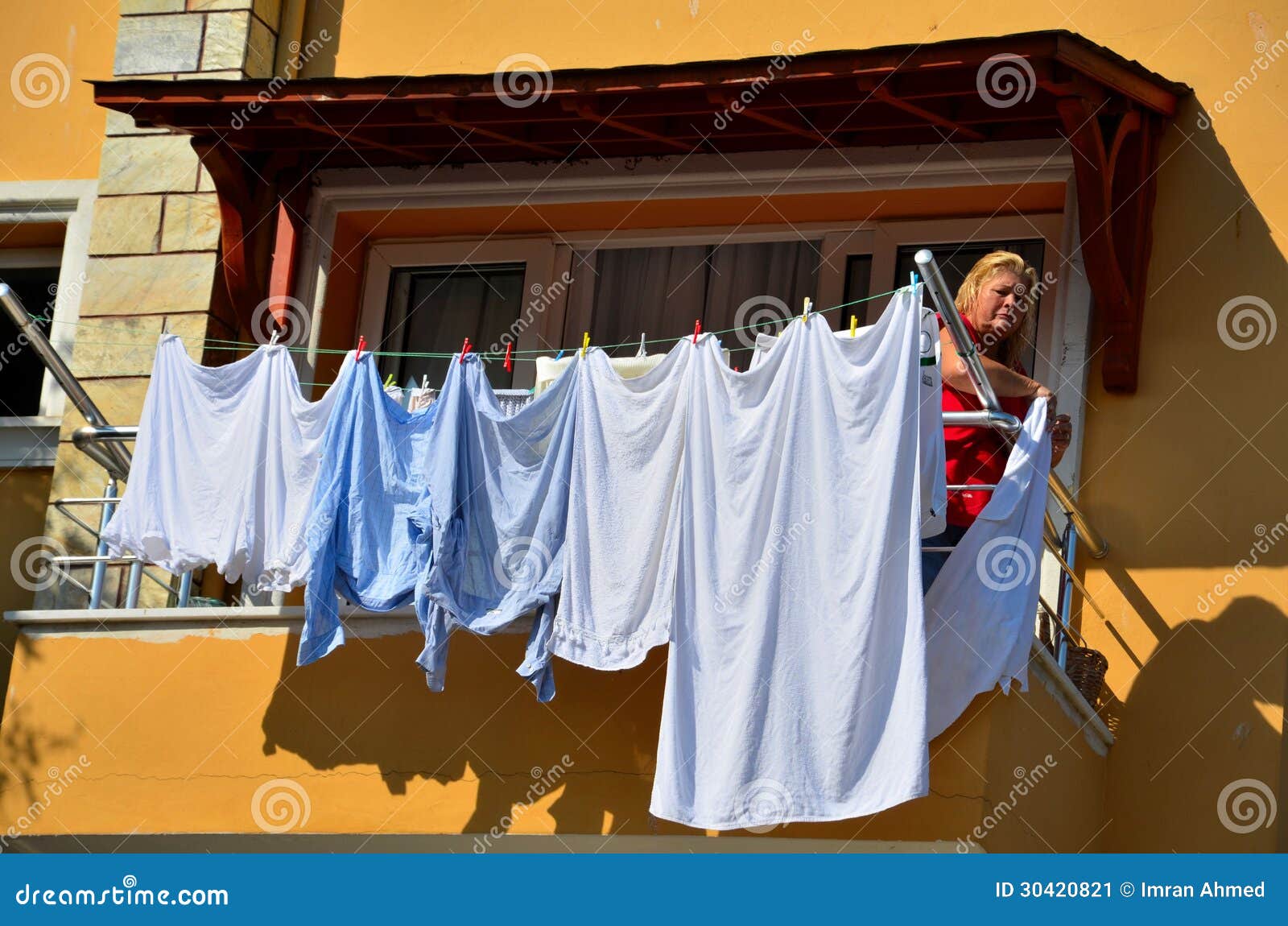 Η τουρκική γυναίκα κρεμά το πλυντήριο που ξεραίνει από το μπαλκόνι Εκδοτική  Εικόνες - εικόνα από : 30420821