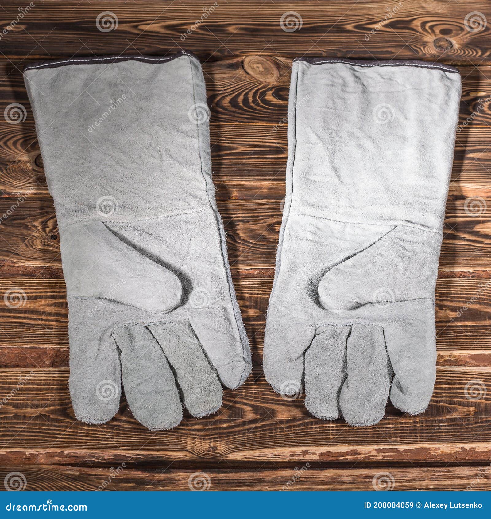 λευκά δερμάτινα γάντια ασφαλείας σε ξύλινο φόντο. φωτογραφία στούντιο με  έντονο φωτισμό Στοκ Εικόνα - εικόνα από multipurpose, accidence: 208004059