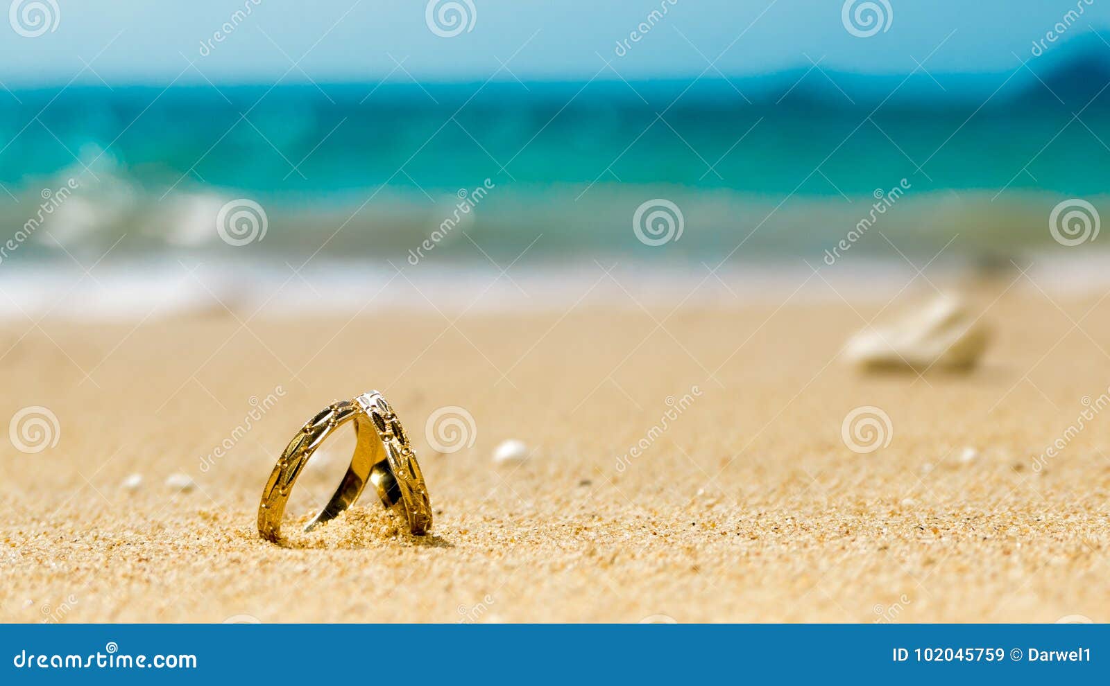 Μήνας του μέλιτος στο τροπικό νησί, δύο γαμήλια δαχτυλίδια στην αμμώδη  παραλία Στοκ Εικόνα - εικόνα από bazaars: 102045759