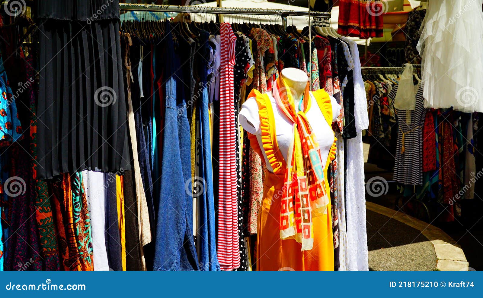 μεταχειρισμένα ρούχα διαφόρων χρωμάτων που εμφανίζονται σε πάγκο στην αγορά  μεταχειρισμένων πορτά που φέρονται στη ρώμη Εκδοτική εικόνα - εικόνα από  antiquate, bagel: 218175210