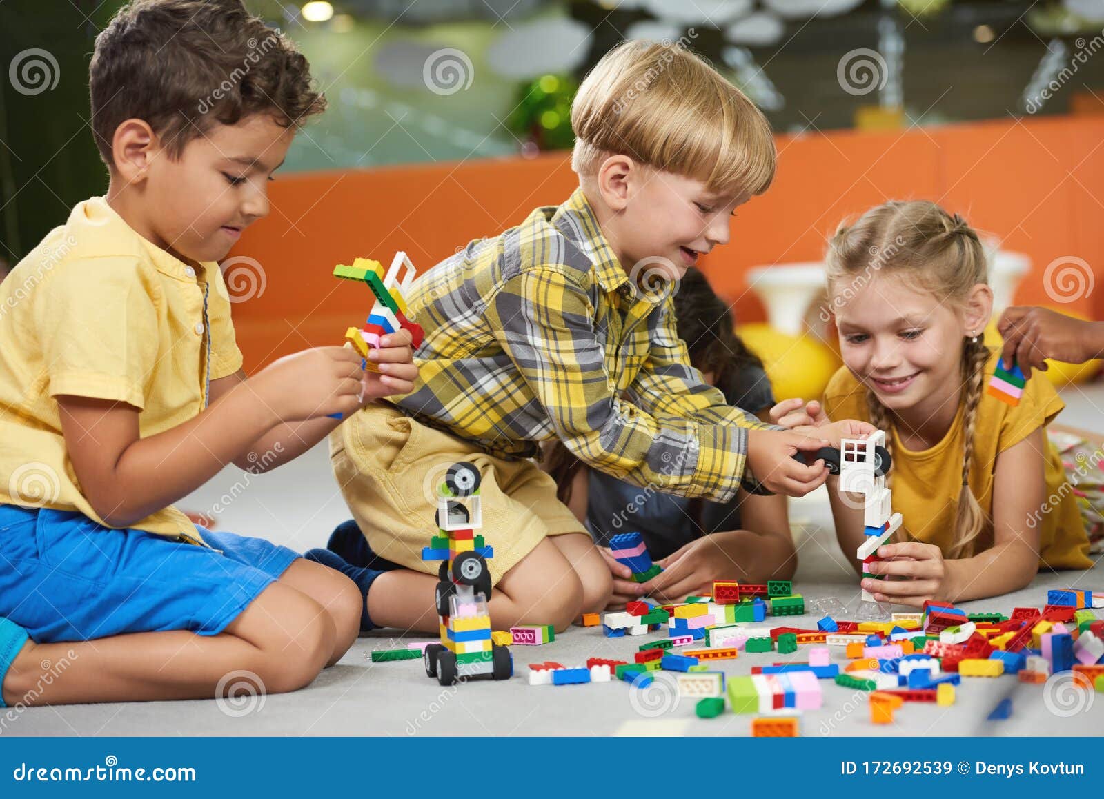 μικρά παιδιά που παίζουν με παιχνίδια κατασκευών στο πάτωμα. Στοκ Εικόνα -  εικόνα από childcare, lifestyle: 172692539