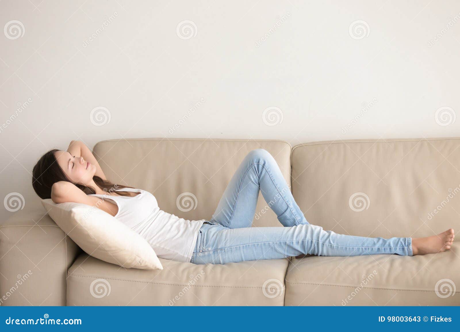 deficit react meat Νέα γυναίκα που βρίσκεται στον καναπέ, που χαλαρώνει με τα χέρια πίσω από  το κεφάλι Στοκ Εικόνα - εικόνα από lifestyle: 98003643