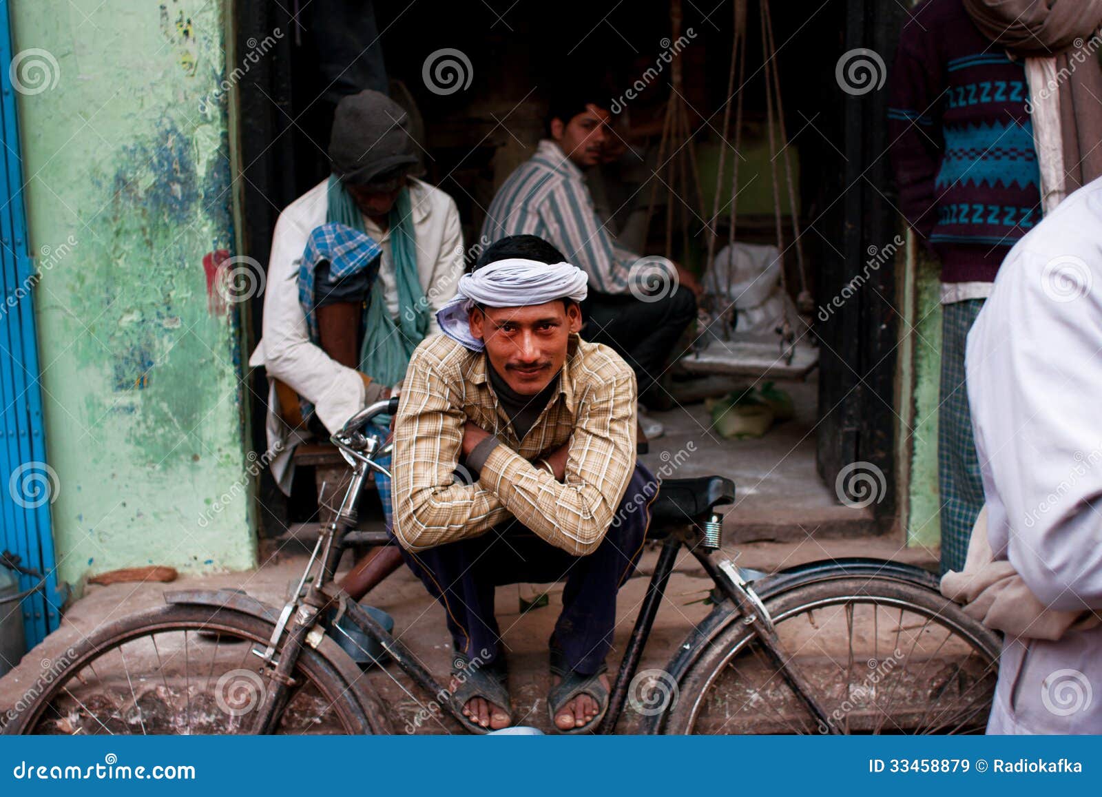Ο εργαζόμενος σε ένα τουρμπάνι στηρίζεται την κλίση στο αναδρομικό ποδήλατό  του στην οδό Εκδοτική Στοκ Εικόνα - εικόνα από lifestyle, antiquate:  33458879