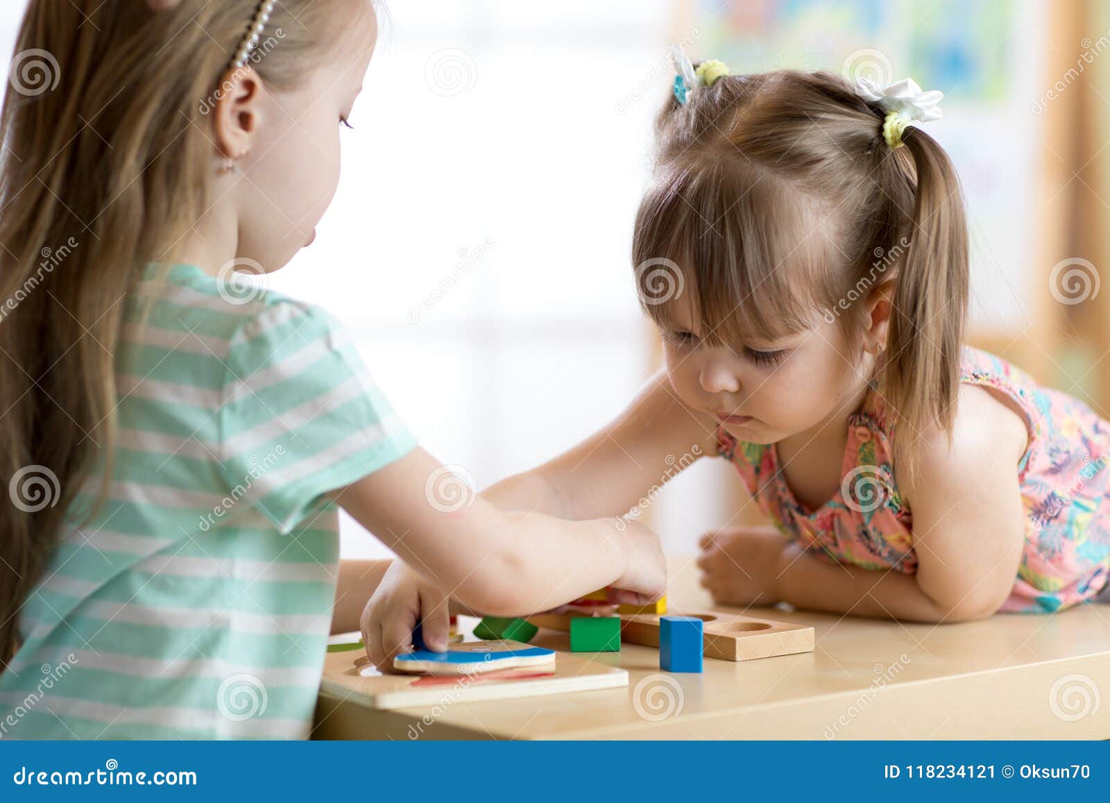 Παιδιά που παίζουν με τα ζωηρόχρωμα παιχνίδια φραγμών Δύο κορίτσια παιδιών  στο σπίτι ή κέντρο φύλαξης Εκπαιδευτικά παιχνίδια παιδ Στοκ Εικόνα - εικόνα  από childhood, babylonia: 118234121