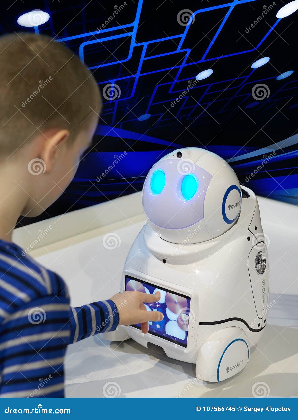 Τα παιχνίδια αγοριών με ένα ρομπότ σε ένα σκοτεινό υπόβαθρο με ένα  ολογράφημα Εκδοτική εικόνα - εικόνα από babysit, childhood: 107566745