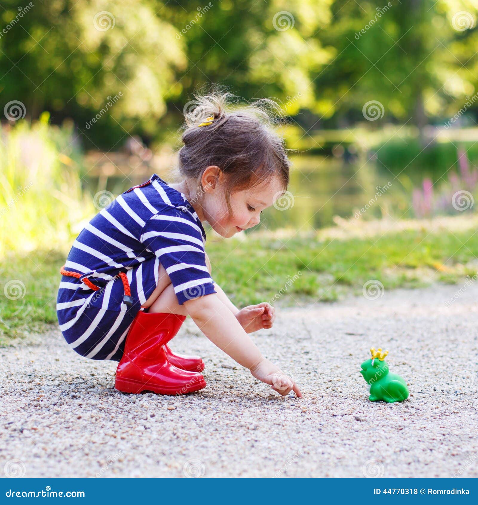 Όμορφο μικρό κορίτσι στις κόκκινες μπότες βροχής που παίζει με το  λαστιχένιο βάτραχο Στοκ Εικόνες - εικόνα από childhood: 44770318