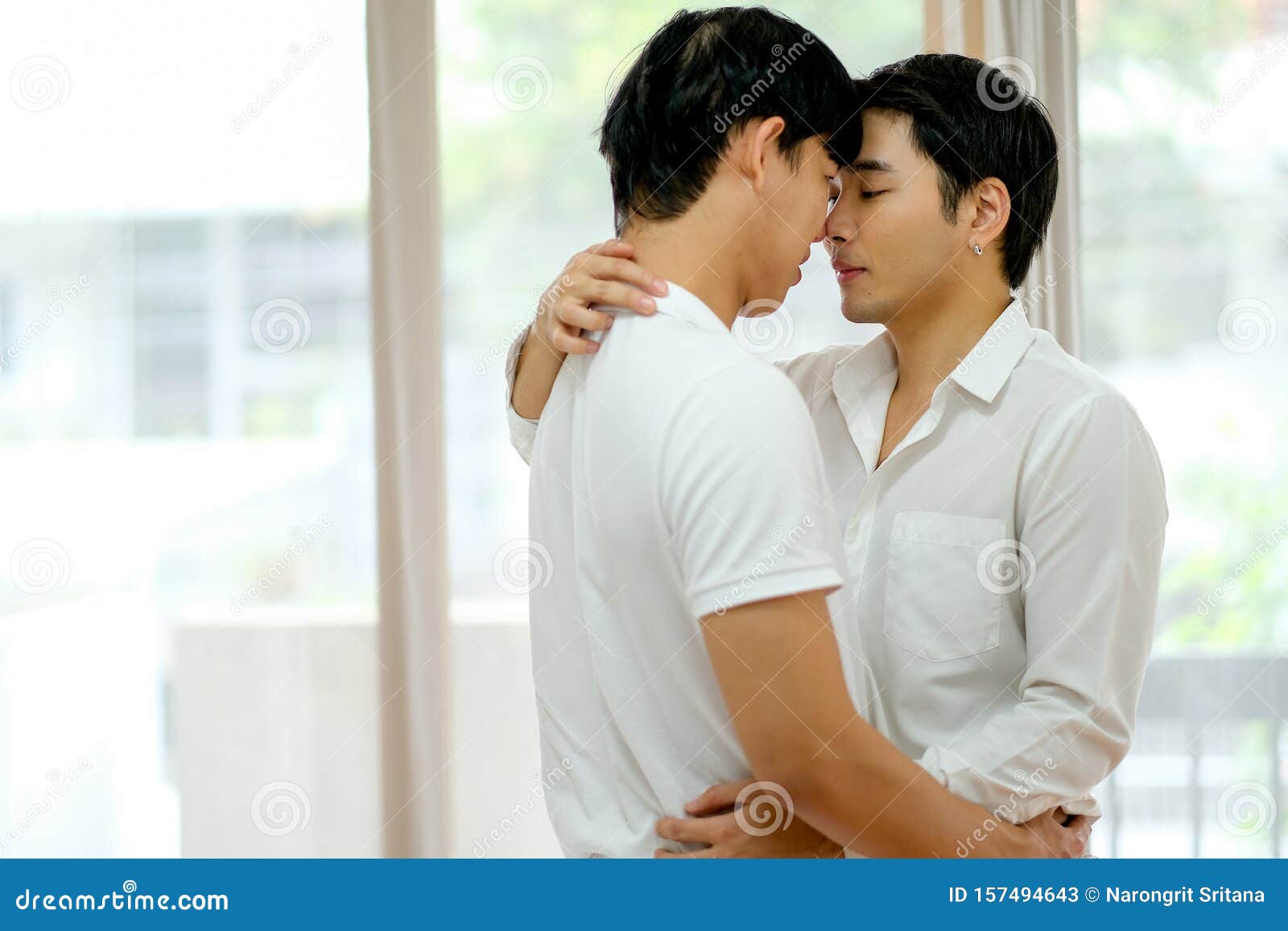 Азиатская пара геев с белой рубашкой целуется вместе в спальне с дневным светом Стоковое Изображение - изображение насчитывающей вскользь, привлекательностей: 157494643
