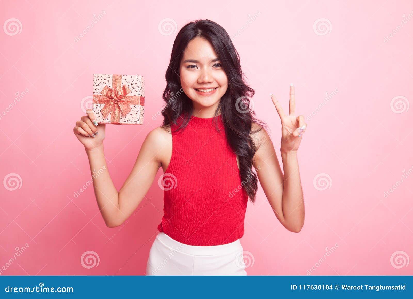 Азиатская женщина с подарками. Азиат с подарком. Подарок в руках серый фон. Казашка с коробками стоковое фото на однотонном фоне.