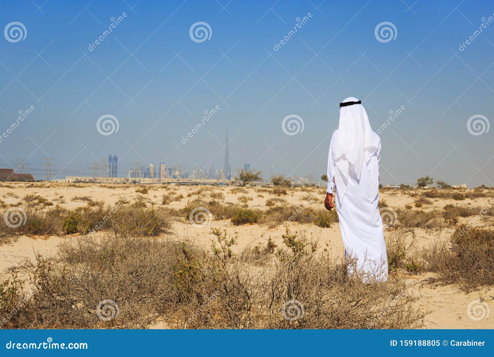 Араб в национальной одежде стоит в пустыне Стоковое Изображение - изображение насчитывающей пустыня, верблюд: 159188805