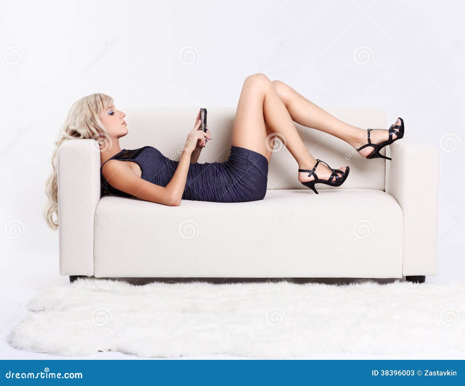 Тетке на диване. Девушка лежит на диване. Блондинка девушка на диване лежит. Девушка со смартфоном на диване. Девушка полулежа на диване.
