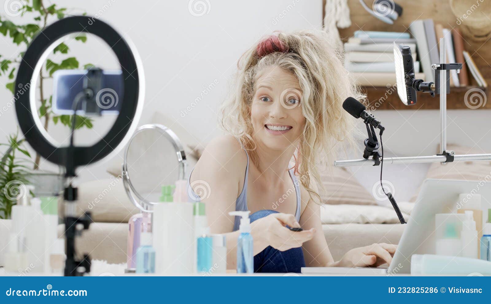 блондинка-улыбающаяся женщина-влиятельный блогер записывает видео-учебник на смартфонной камере, проверяя оборудование на показ то Стоковое Фото - изображение насчитывающей дом, кольцо: 232825286