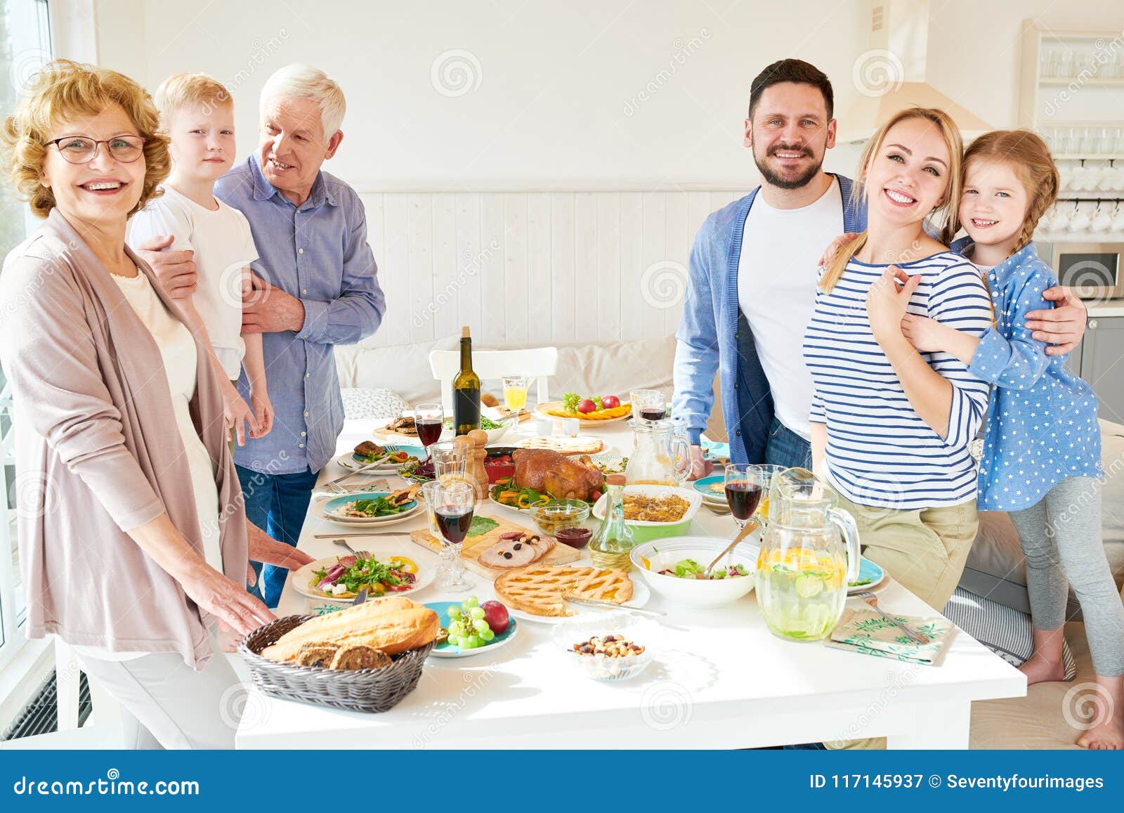 Большая счастливая семья представляя на обеденном столе Стоковое ...