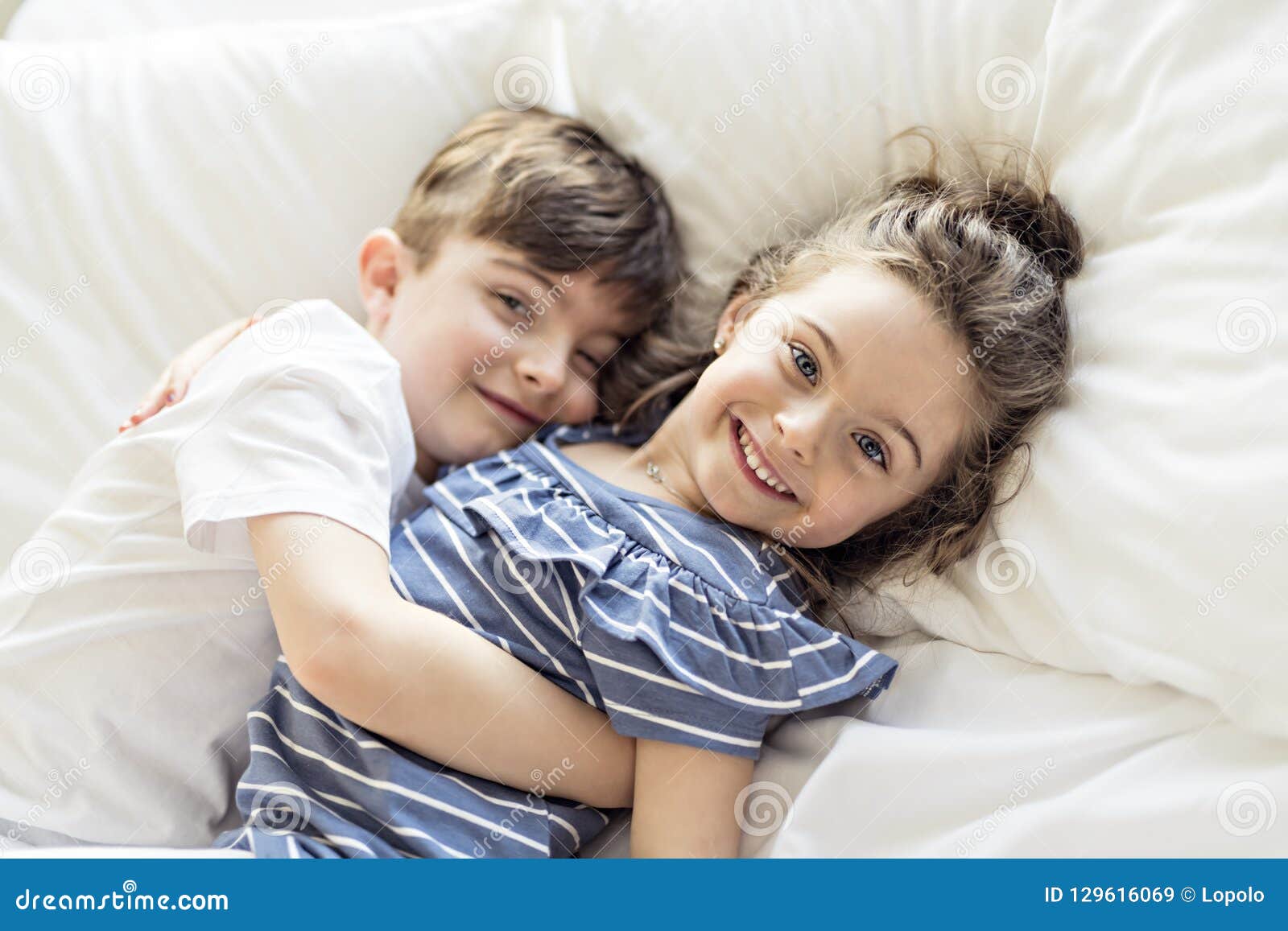 Сын с сестрой занимаются. Братик и сестричка в кровати. Фотосессия брат и сестра. С сестренкой в постели. Мальчик лежит на маме.