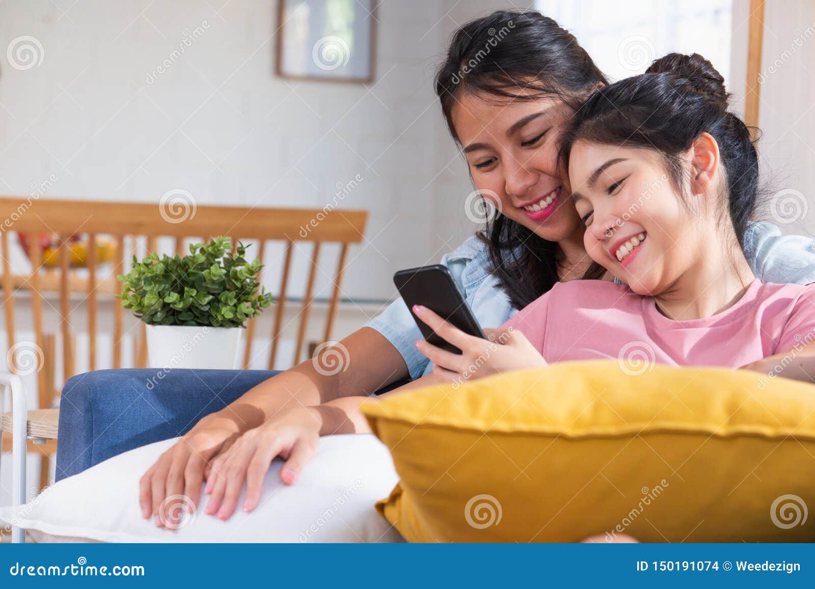 Видео счастливой азиатской лесбиянки наблюдая на мобильном телефоне на софе в доме Концепция образа жизни LGBTQ Стоковое Фото - изображение насчитывающей пары, девушки: 150191074
