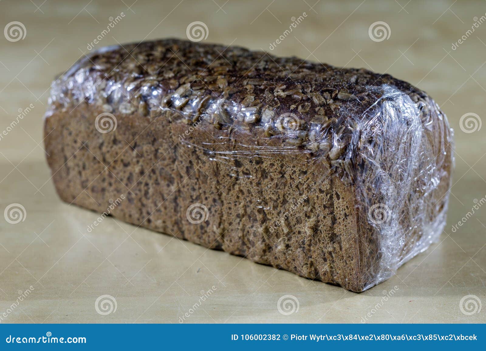 Вкусный черный хлеб с солнцецветом Хлеб упакованный в фольге на древесине  Стоковое Фото - изображение насчитывающей еда, упаковывать: 106002382