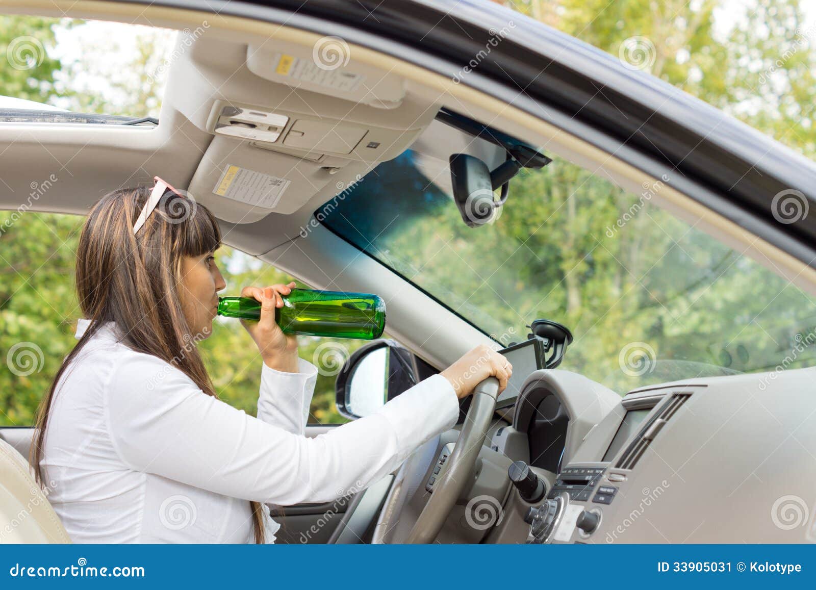 Водитель пьет за рулем. Алкоголь за рулем. Женщина пьет за рулем. Довольная автоледи.