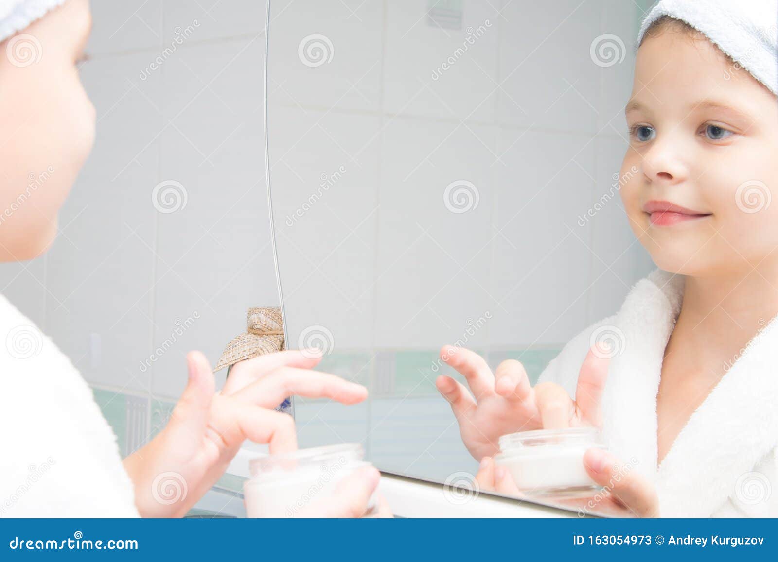 Телочка в ванной смотрит в зеркало