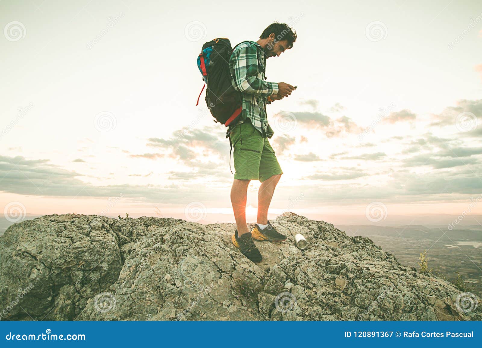 Гай смотря его сотовый телефон на горе Hiker смотря его мобильный телефон в  горах Стоковое Изображение - изображение насчитывающей прием, одно:  120891367