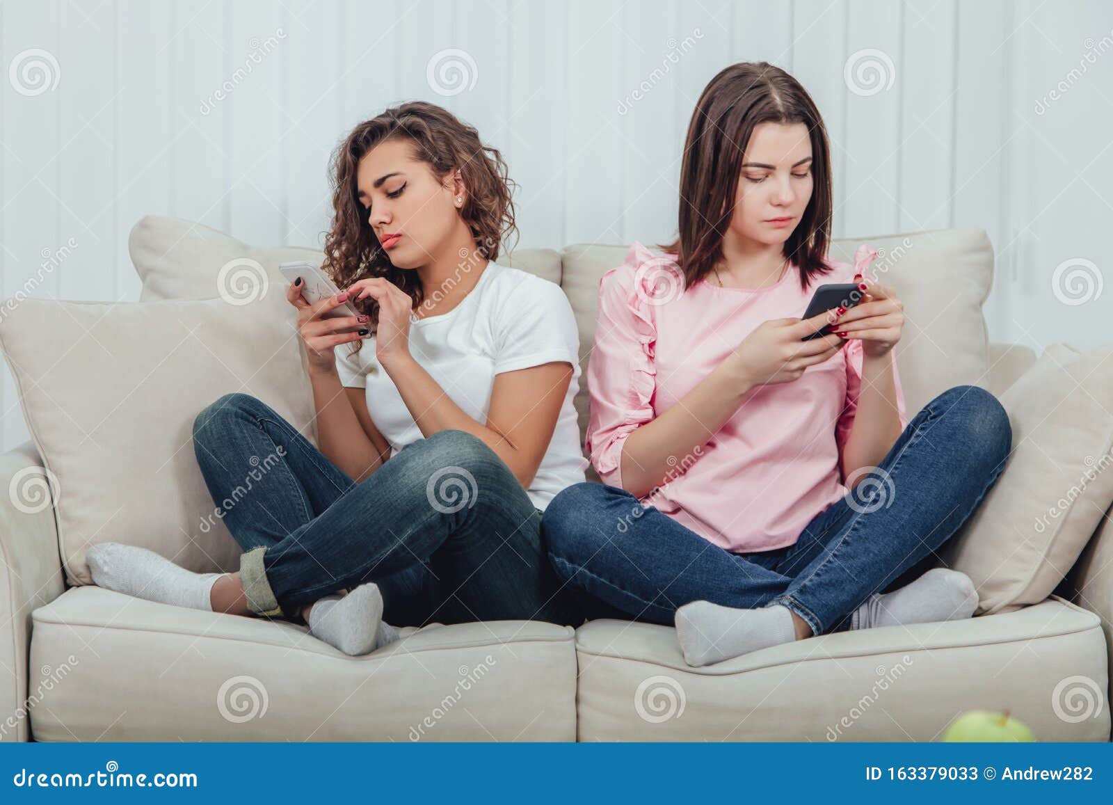 Подруга сидит в телефоне. Подруги сидят на диване. Две девушки сидят на диване. Две подруги на диване. Две подружки сидят в смартфоне.