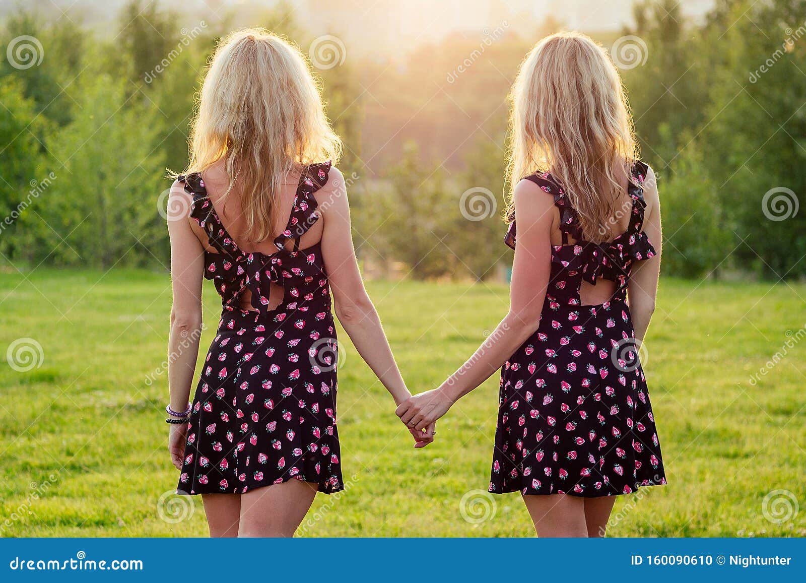Две сестры-лесбиянки близнецы, красивые вьющиеся блондинки в стильном платье, держащем за руки на закате летнего парка Стоковое Фото - изображение насчитывающей девушка, гомосексуально: 160090610