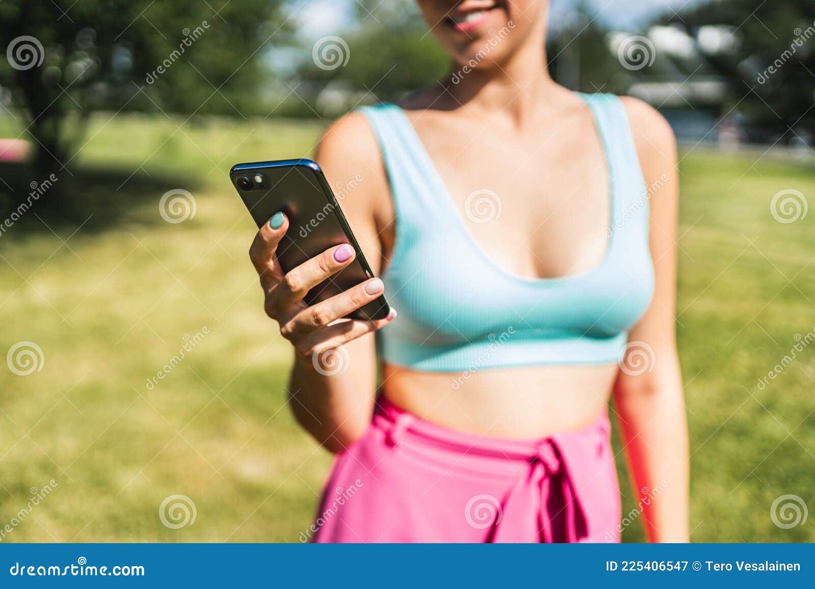 девушка пользуется телефоном и смсками летом в парке. женщина ищет  Sms-сообщение со смартфоном. мобильный телефон. Стоковое Изображение -  изображение насчитывающей трава, пригодность: 225406547