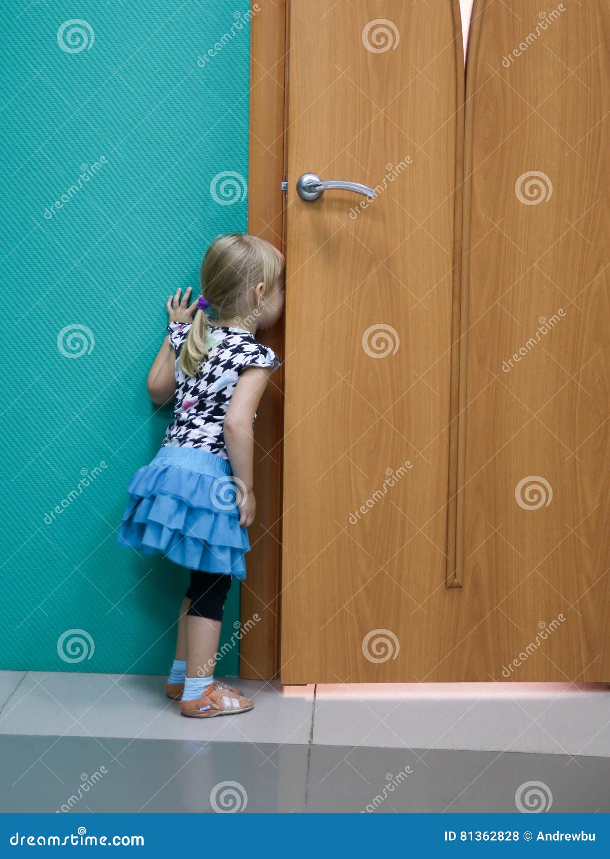 Заметила что за ней подглядывают. Девочка за дверью. Девочка заглядывает в комнату. Заглядывает в дверь.