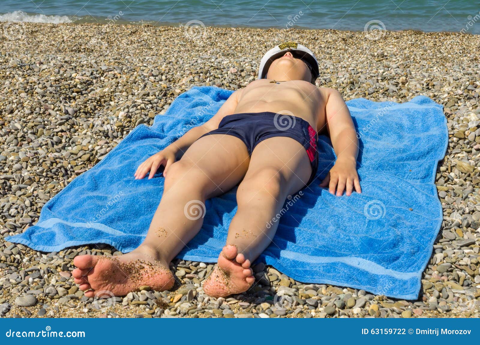 Плавки спящих. Мальчик загорает. Мальчики загорают на пляже. Загорелый мальчик на пляже. Мальчик загорает на берегу.