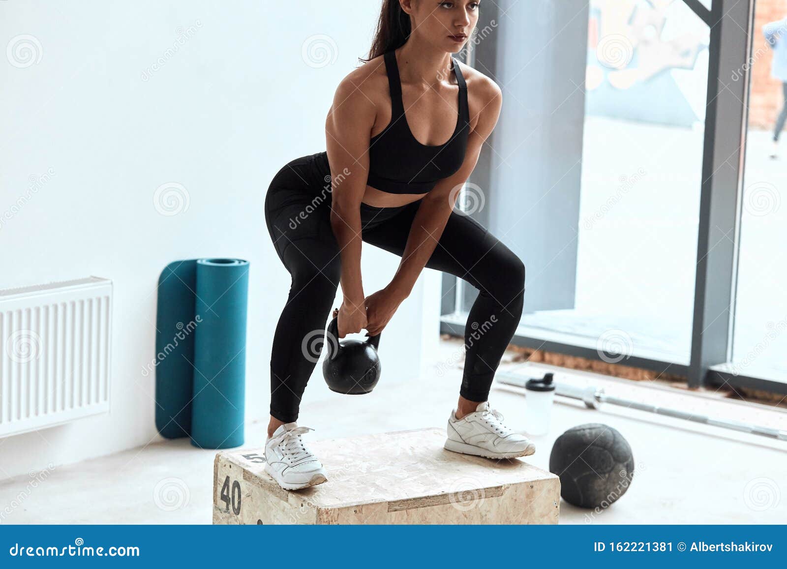Женская тренировка с помощью кэттл-колоколов в тренажерном зале Стоковое Изображение - изображение насчитывающей прочность, мышцы: 162221381