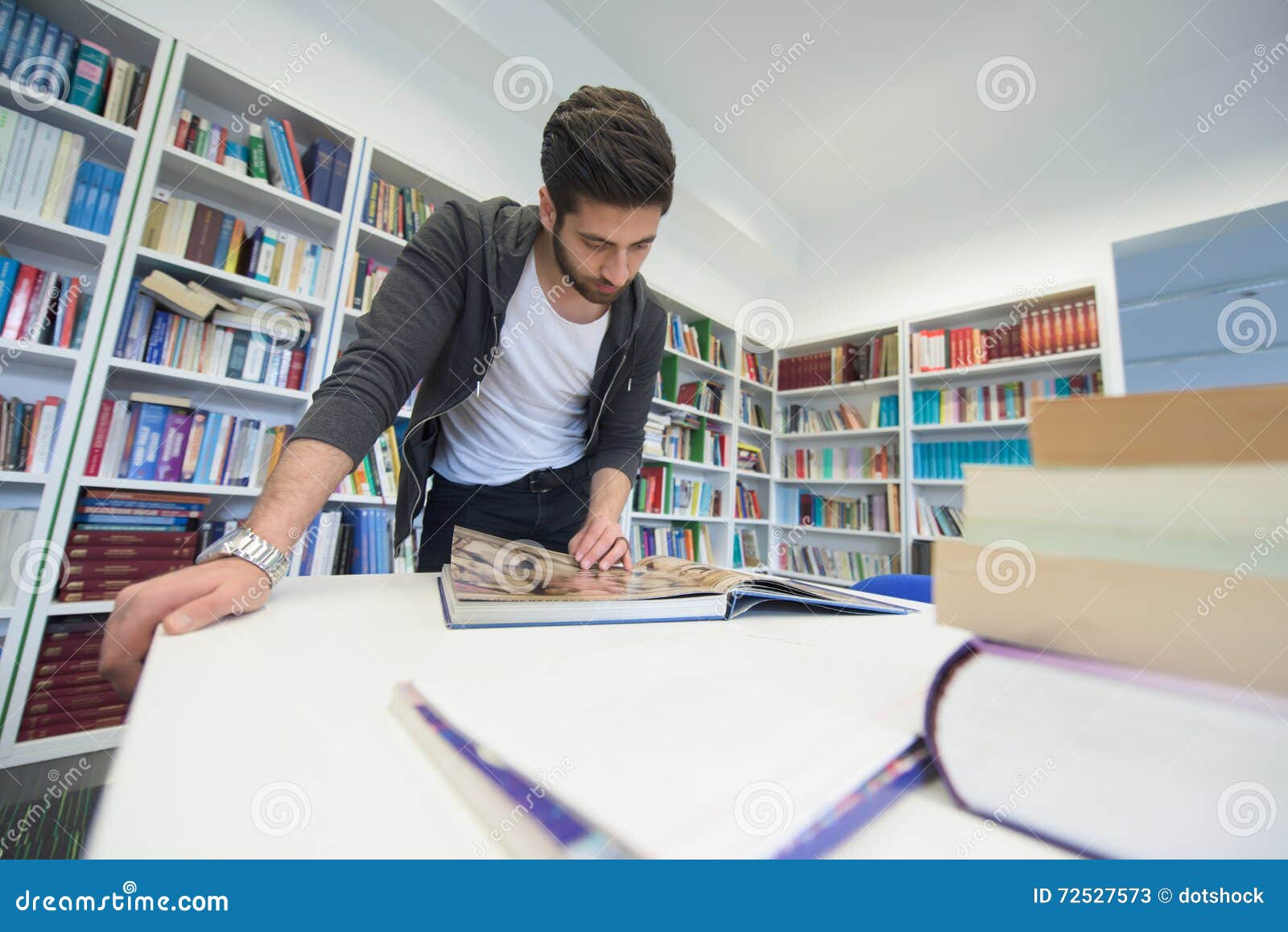 Она сидит в библиотеке. Студенты в библиотеке. Студенты занимаются в библиотеке. Мужчина в библиотеке. Заниматься в библиотеке.