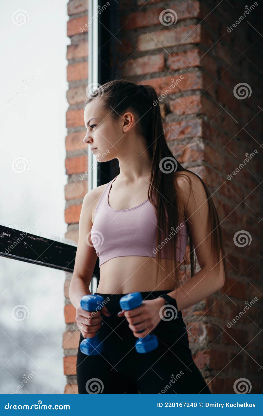 красивая девушка в спортивном топе и черные леггинсы с гантелями в руках смотрит в окно Стоковое Фото - изображение насчитывающей довольно, усмехаться: 220167240