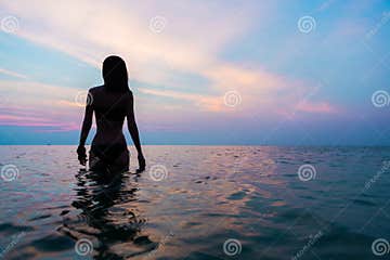 Красивый женский силуэт в море вечера
