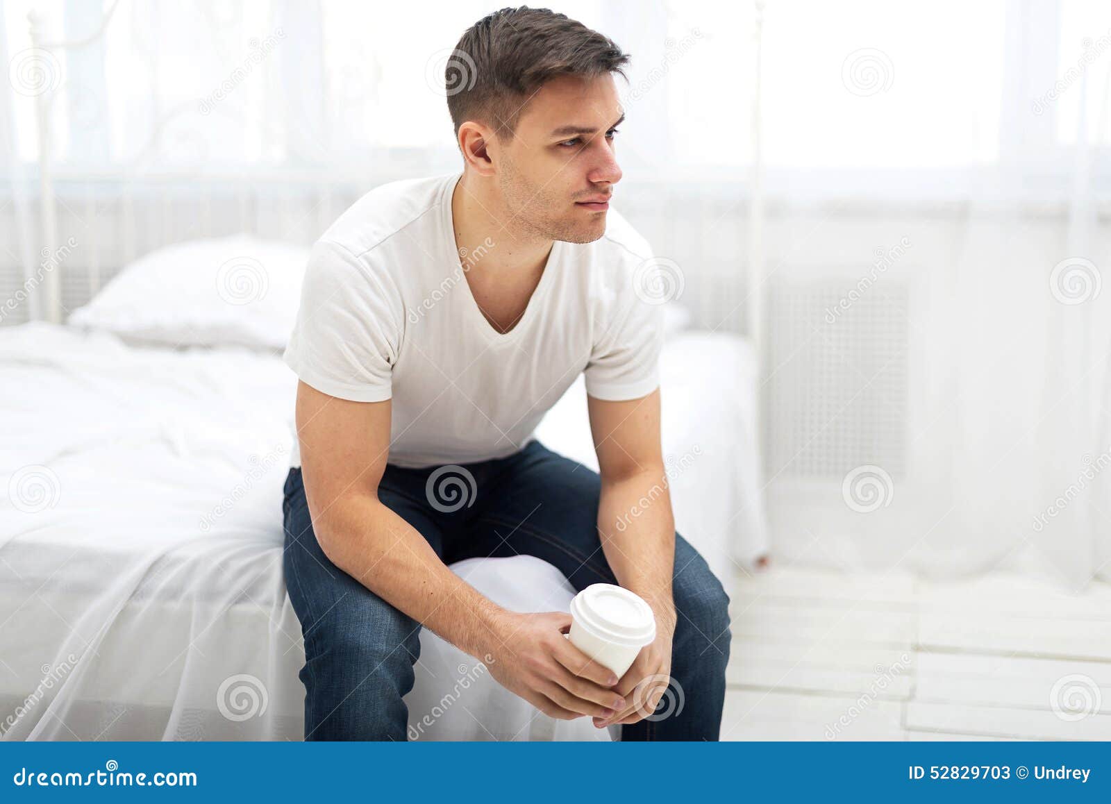 Сонник мужчина сидит. Парень в футболке сидит. Парень в белой футболке. Человек сидит на кровати. Парень в белой майке.