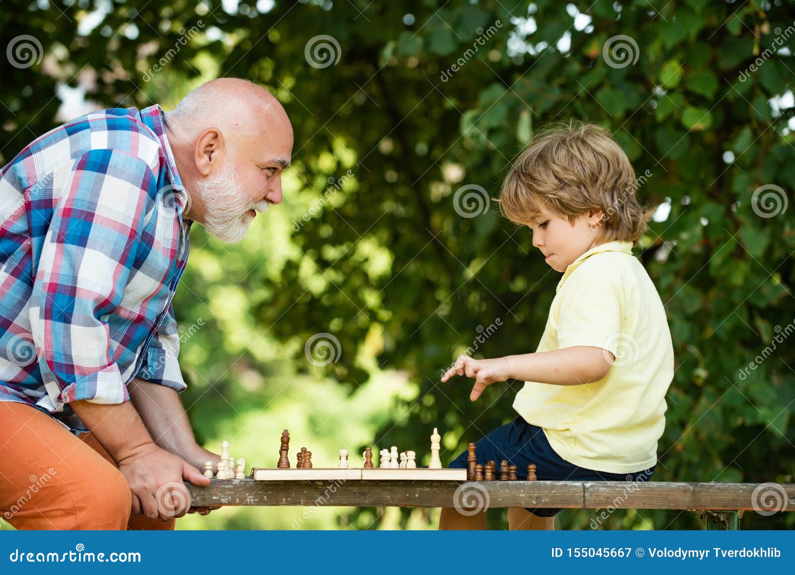 Дед с внуком играют в шашки. Дедушка и внук играют в шахматы. Дедушка с внучкоиграют в шахматы. Дедушка играет с внуком. Мальчик в воздухе.