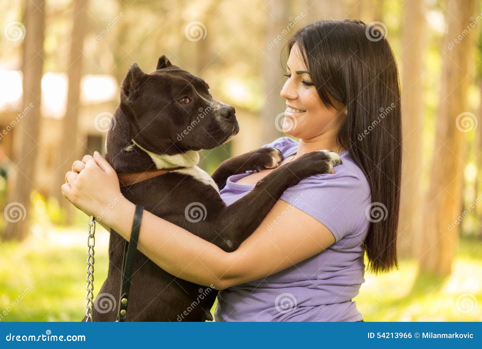 Affectionate Mature Woman Embracing Pet Dog In Nature