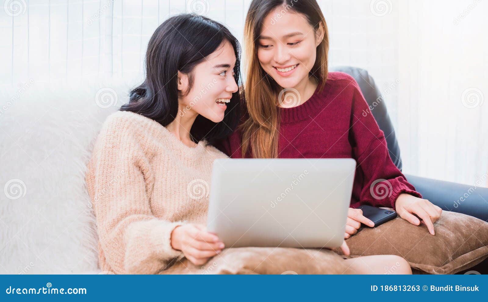 Любитель пар молодых красивых женщин азии лесбиянка с помощью вызова видео смартфона и ноутбука в гостиной дома с улыбкой Стоковое Изображение - изображение насчитывающей девушка, портрет: 186813263