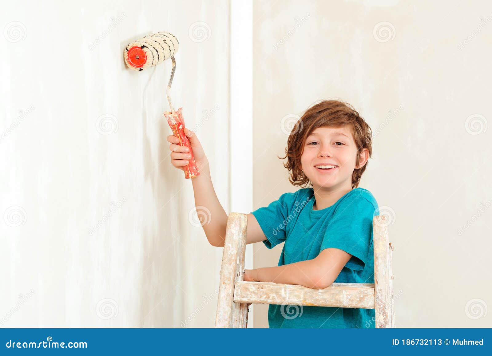 Ребенок красит стену валиком