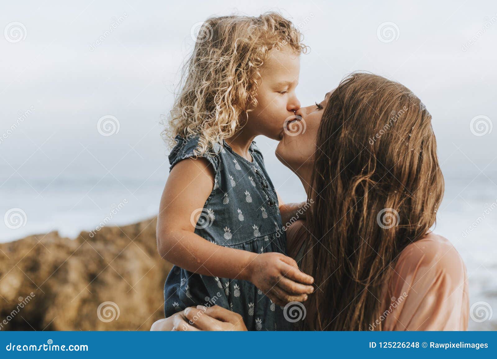 Мама и дочка целуются. Мама целует дочь. Дочь целует маму на пляже. Мама с дочкой поцелуй. Мама с дочкой поцелуй пляж.