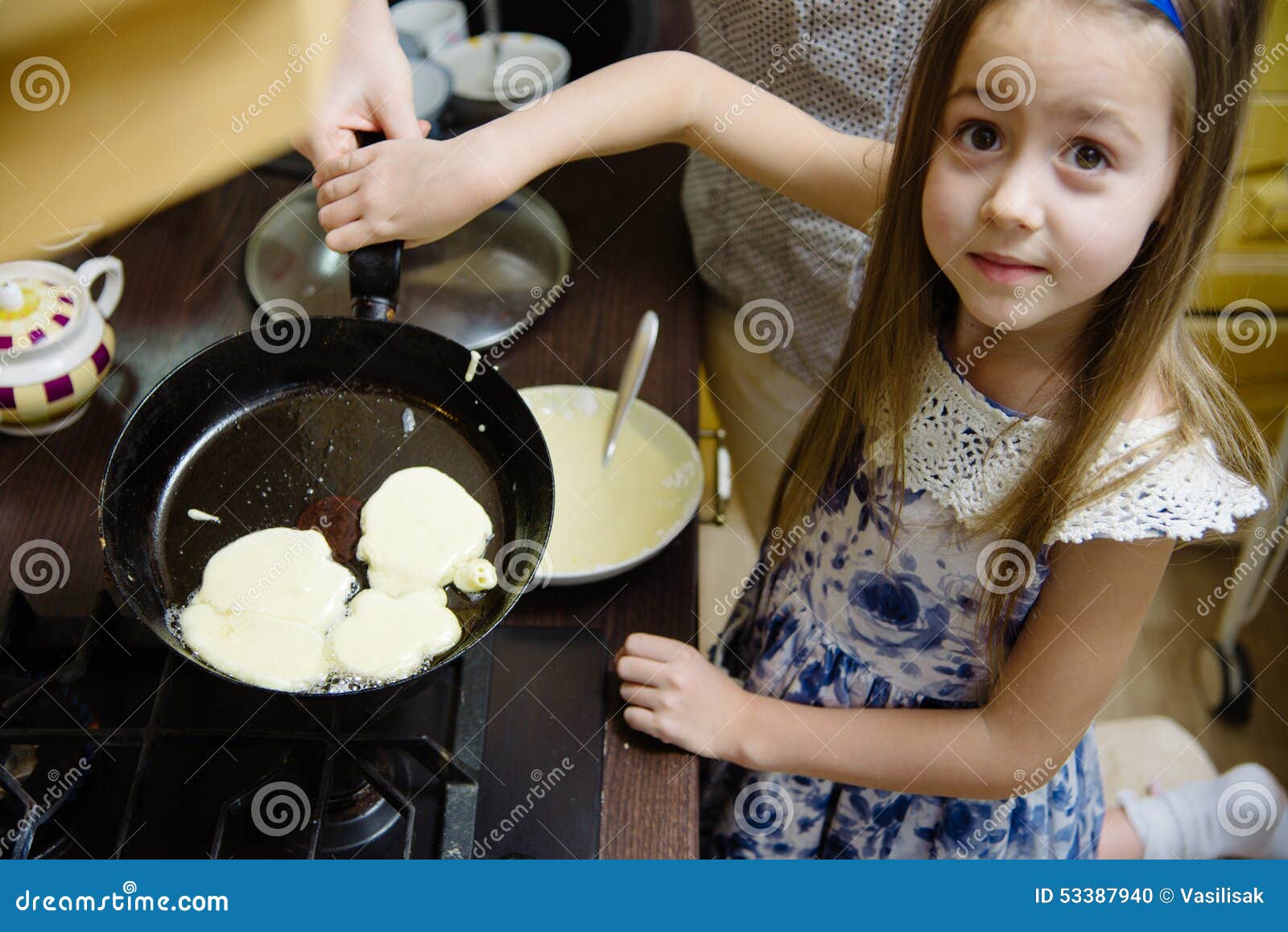 Мама готовит блины. Дети пекут блины. Мама с дочкой пекут блины. Девушка печет блины. Маленькая девочка готовит блины.