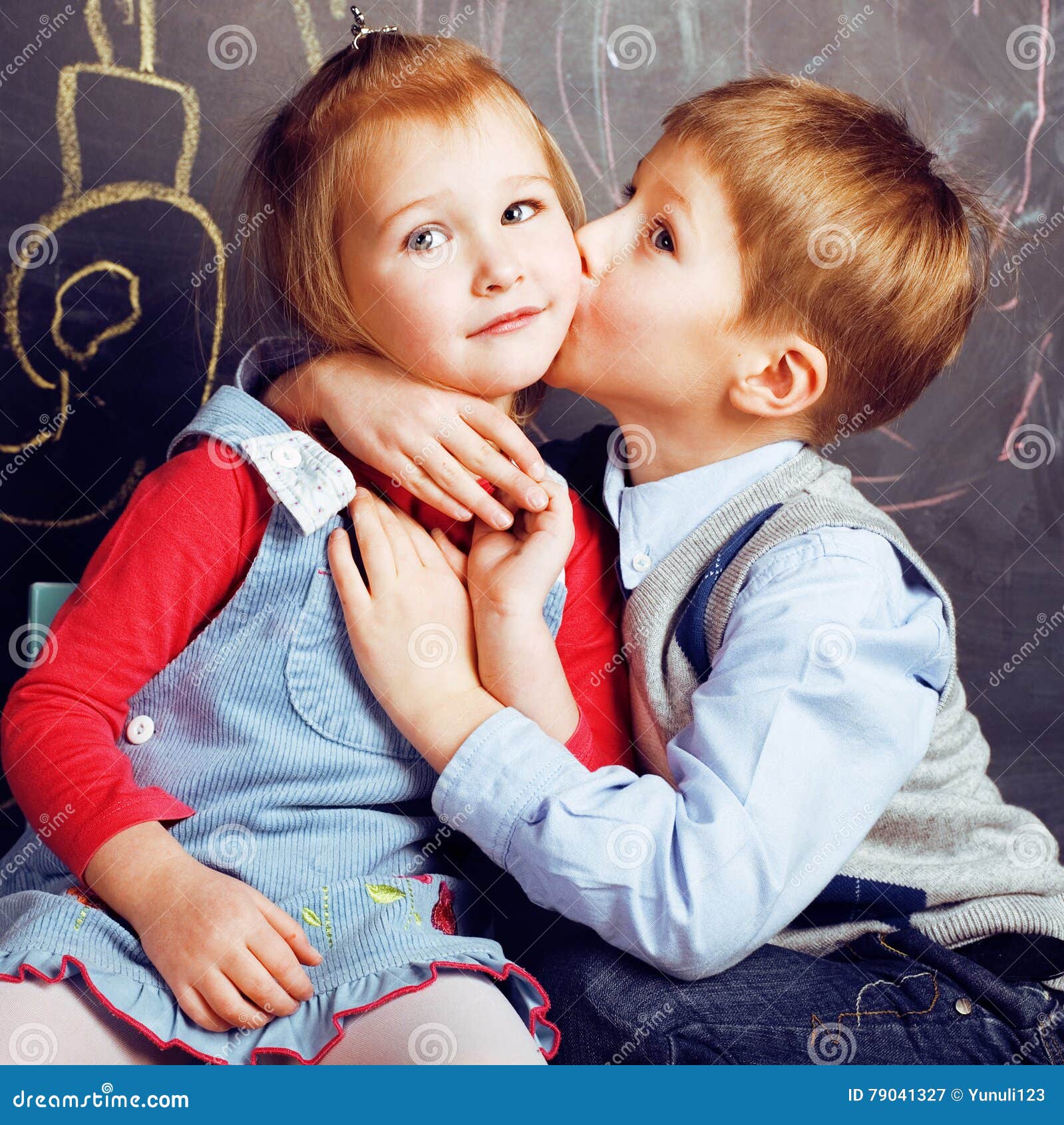 дети пальчик и девочка. девочка целует мальчика на скамейке. дети мальчик и девочка. детский поцелуй. поцелуи мальчик с мальчиком.
