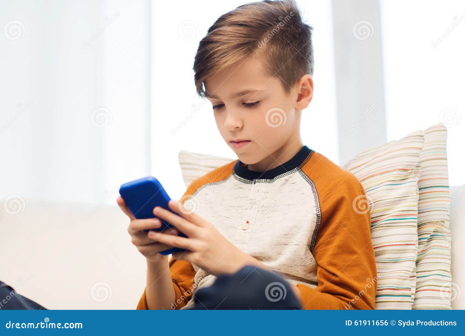 Мальчик при Smartphone отправляя СМС или играя дома Стоковое Фото -  изображение насчитывающей люди, телефон: 61911656