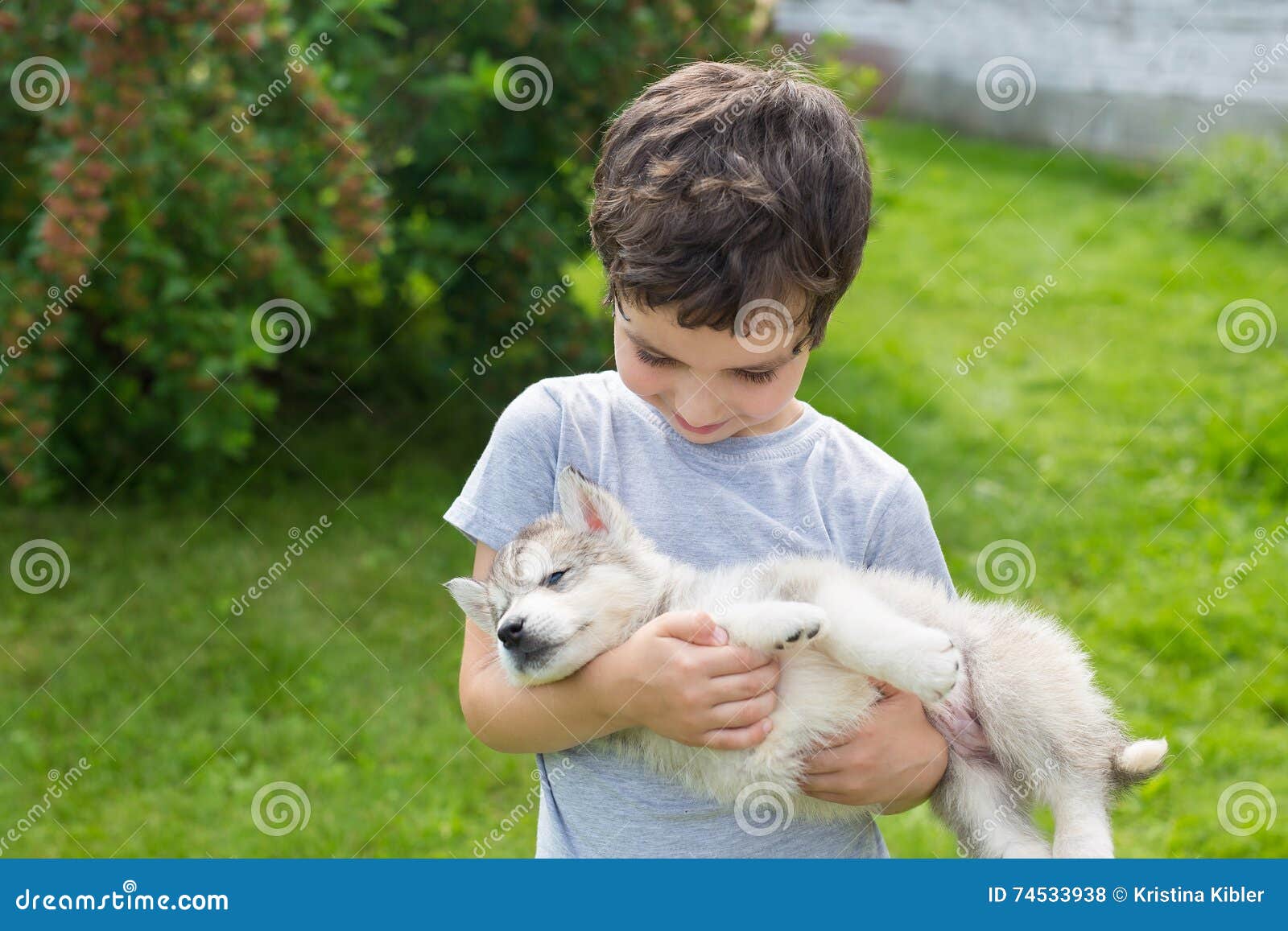 Мальчик держит собаку на руках. Щенок на руках. Щенок на руках у ребенка. Мальчик с щенком в руках.