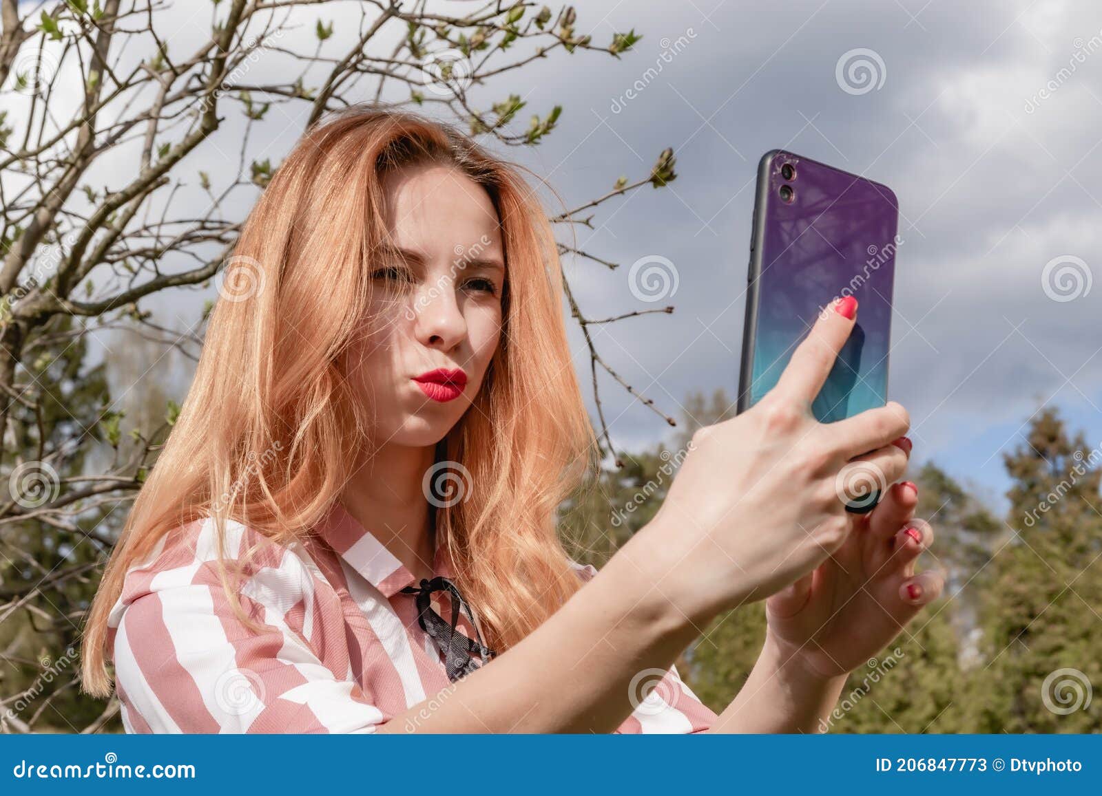Молодая блондинка связывает видео по телефону в парке Стоковое Изображение - изображение насчитывающей мило, потеха: 206847773